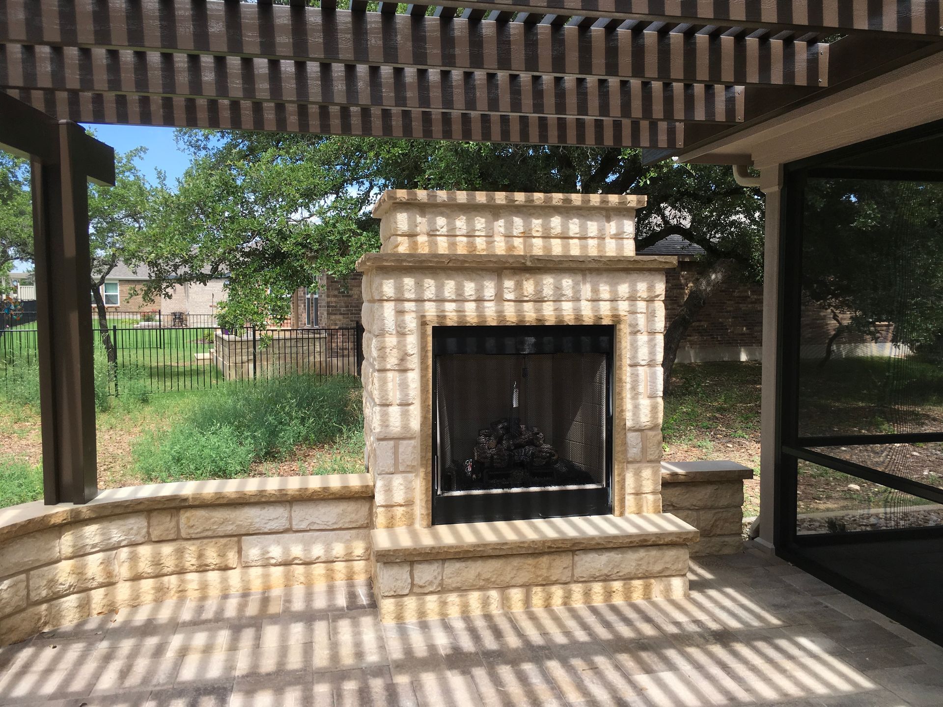 A patio with a fireplace and a screened in porch