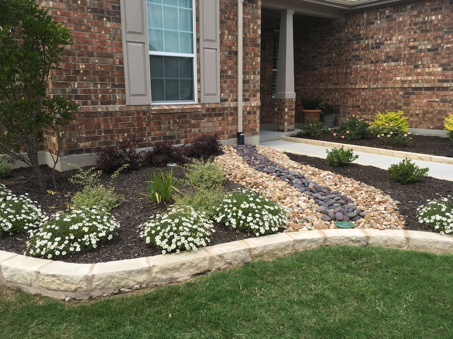 A brick house with a garden in front of it