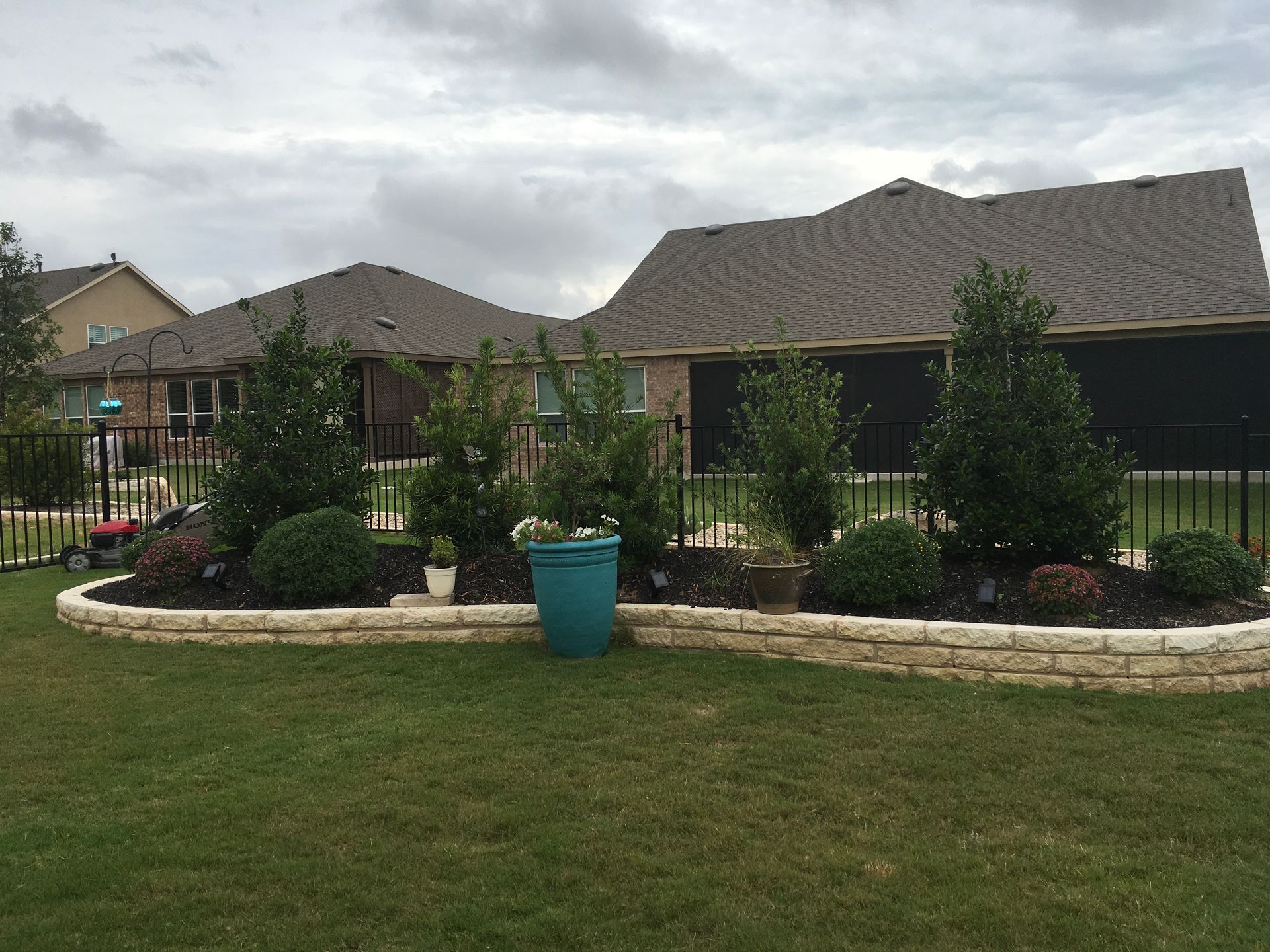 A lawn with a blue pot in front of a house.
