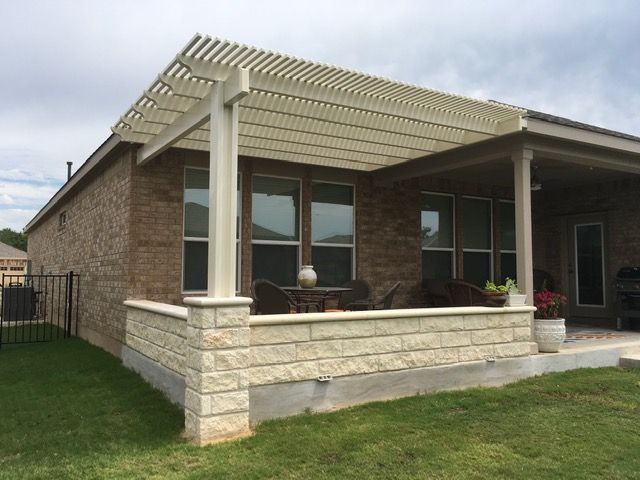 A house with a porch and a pergola on top of it.