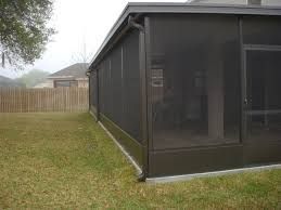 A screened in porch in the backyard of a house.