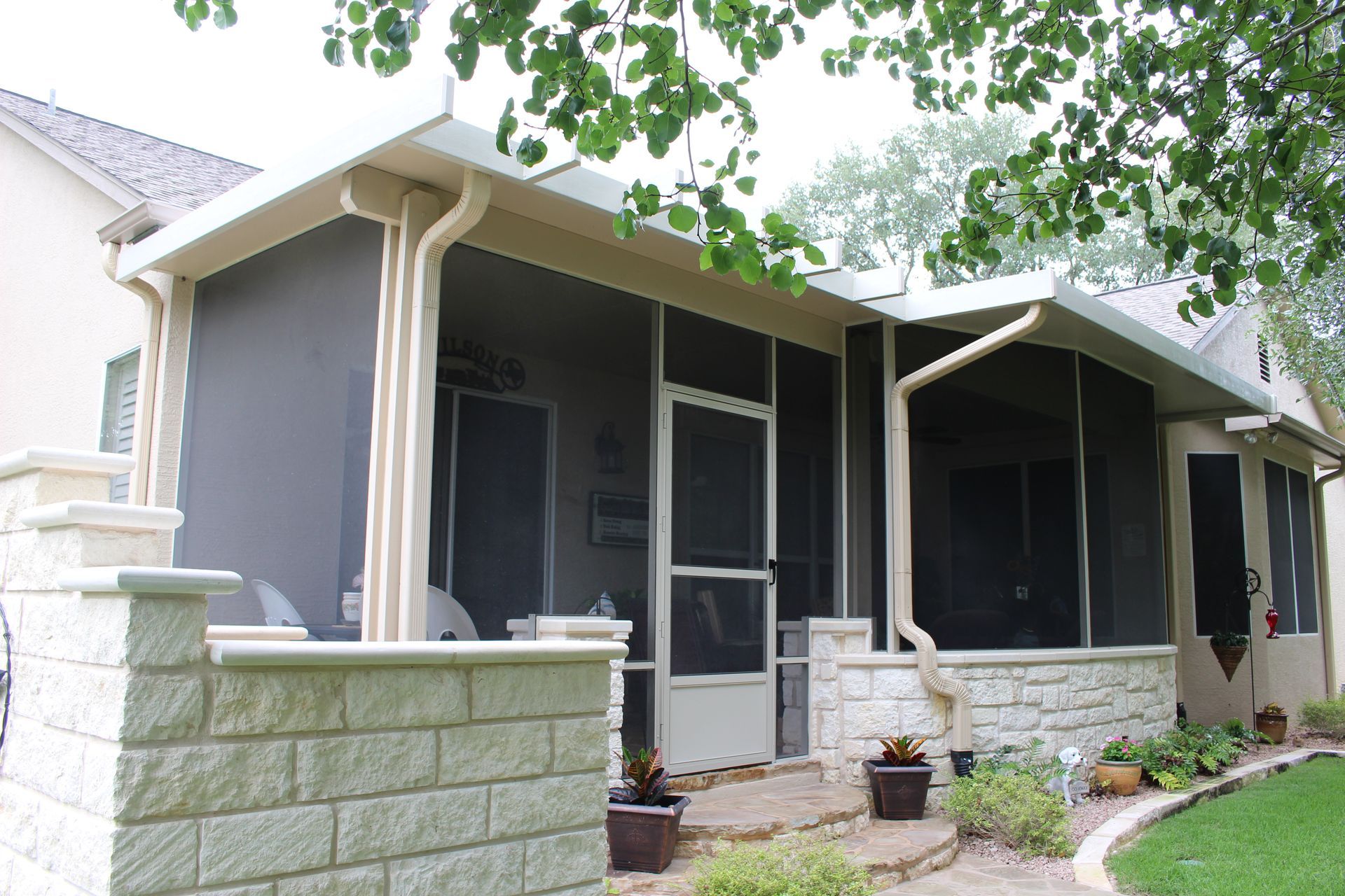 A screened in porch with a brick wall in front of it