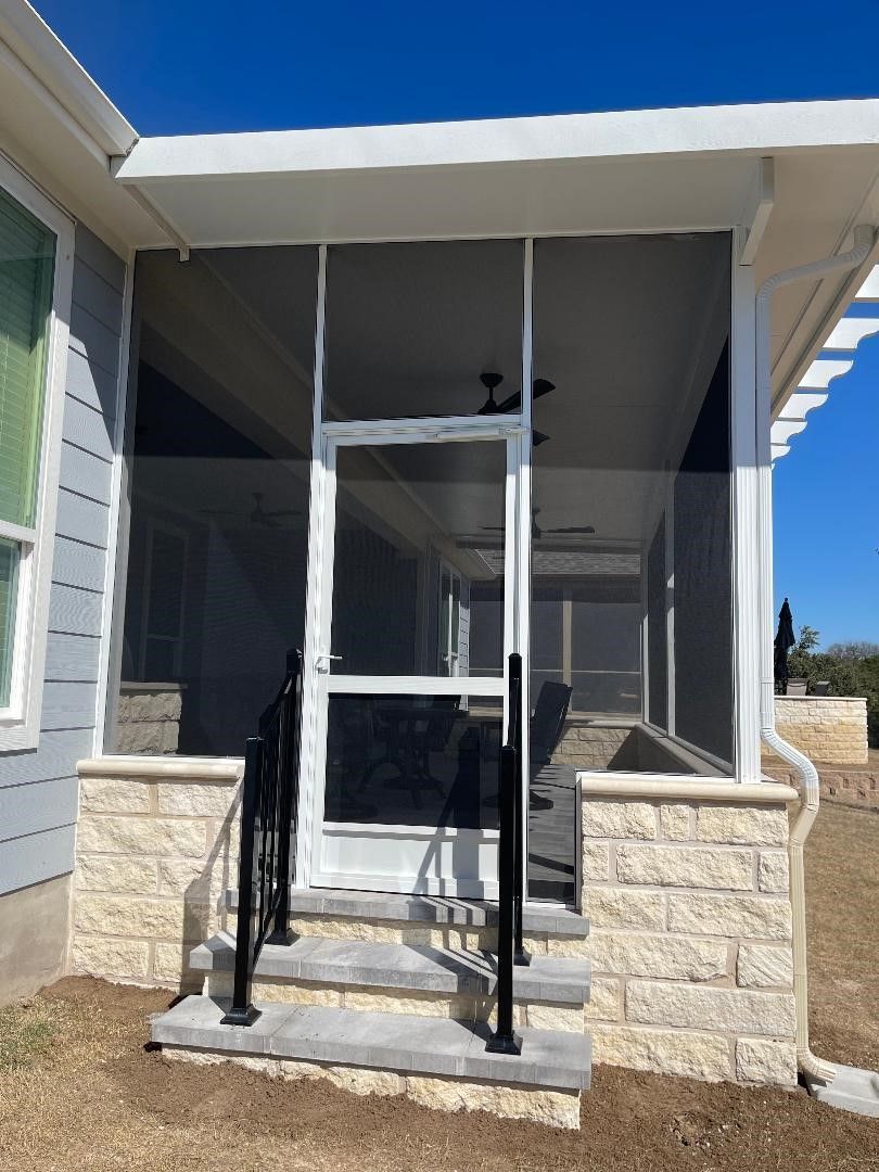 A house with a screened in porch and stairs.