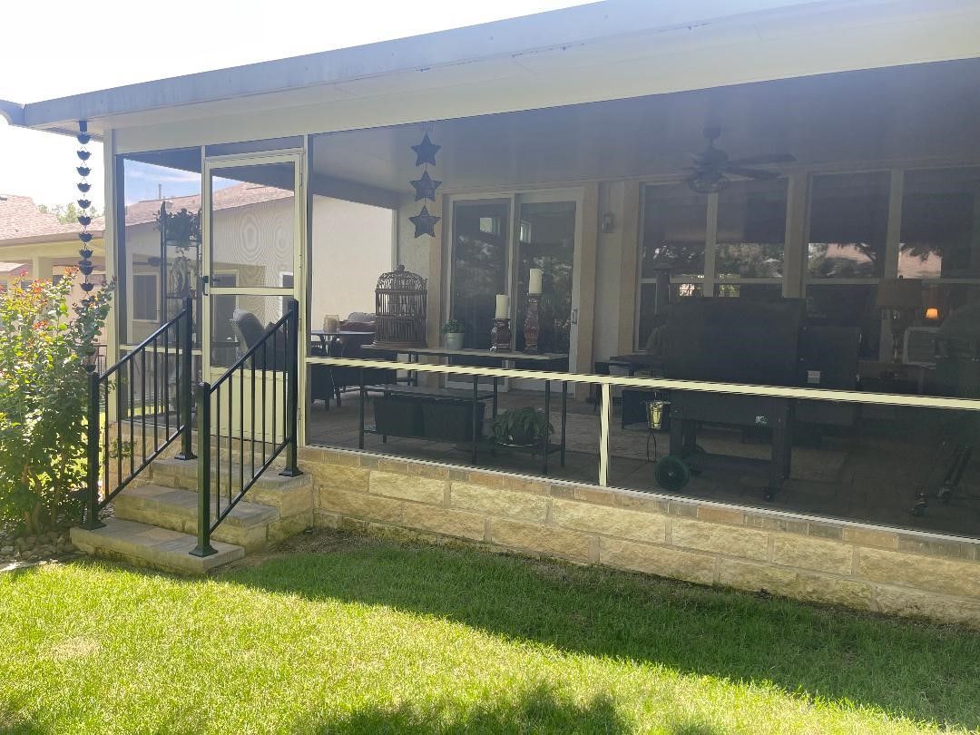 A house with a screened in porch and stairs leading to it.