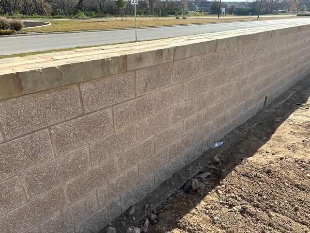 A brick wall with a road in the background