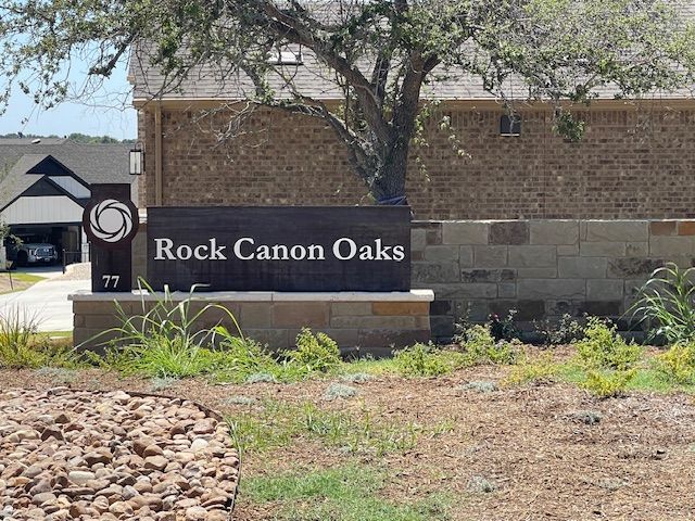 A sign for rock canon oaks is in front of a house