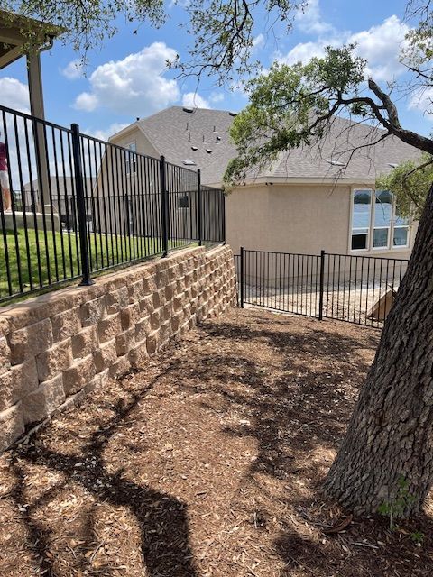 A house with a fence and a tree in front of it