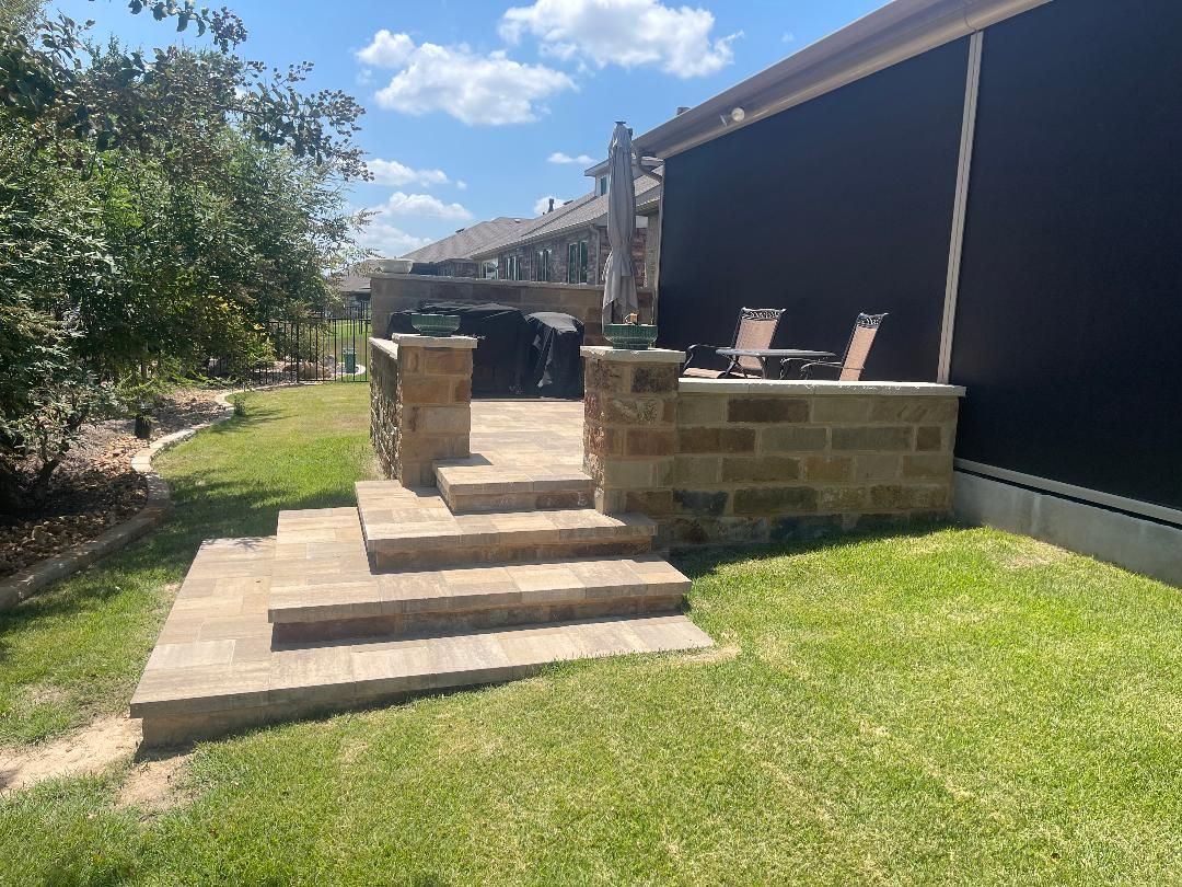 There are stairs leading up to a patio in the backyard of a house.