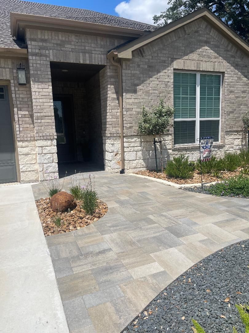 A brick house with a driveway in front of it.