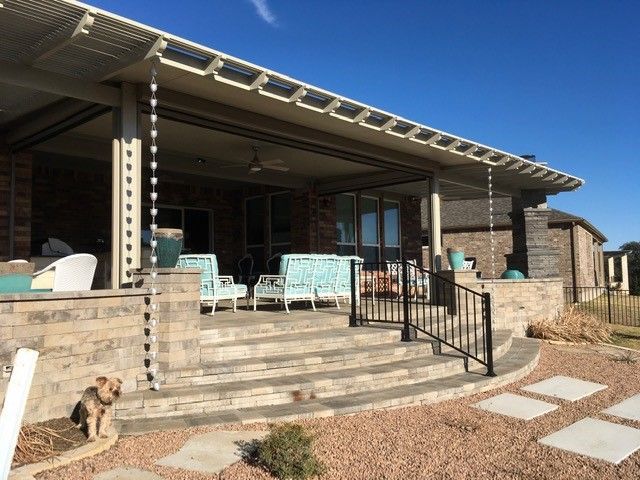 A dog is standing in front of a covered porch