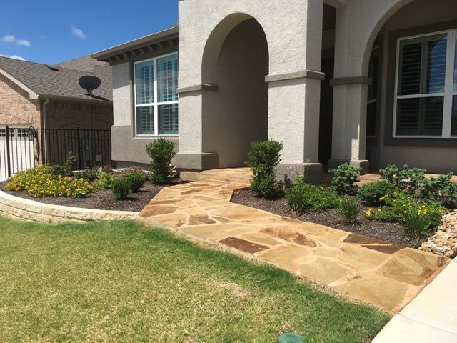 A stone walkway leading to the front of a house