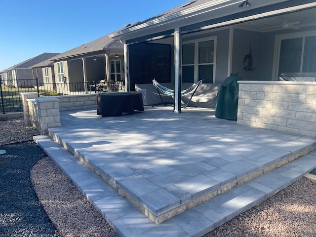 A large patio with stairs leading up to it in front of a house.