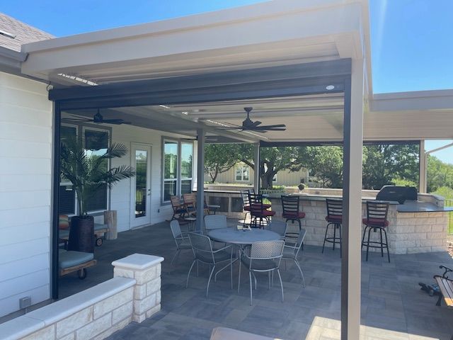 A patio with tables and chairs and a ceiling fan.