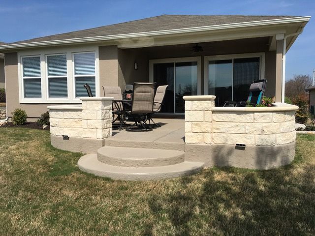 A house with a patio and chairs in front of it.