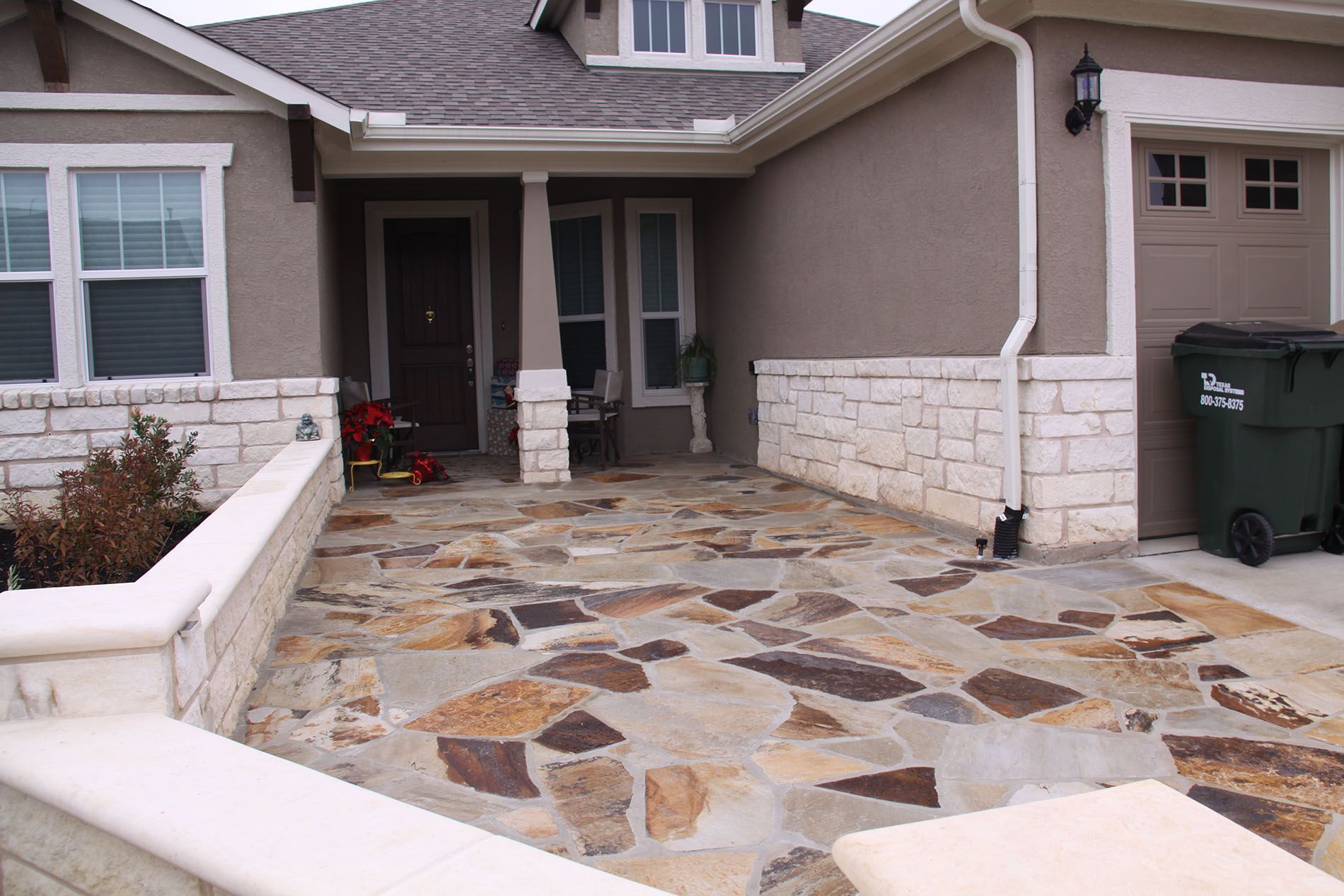A house with a green trash can in front of it