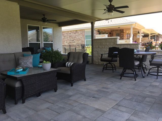 A patio with a table and chairs and a ceiling fan