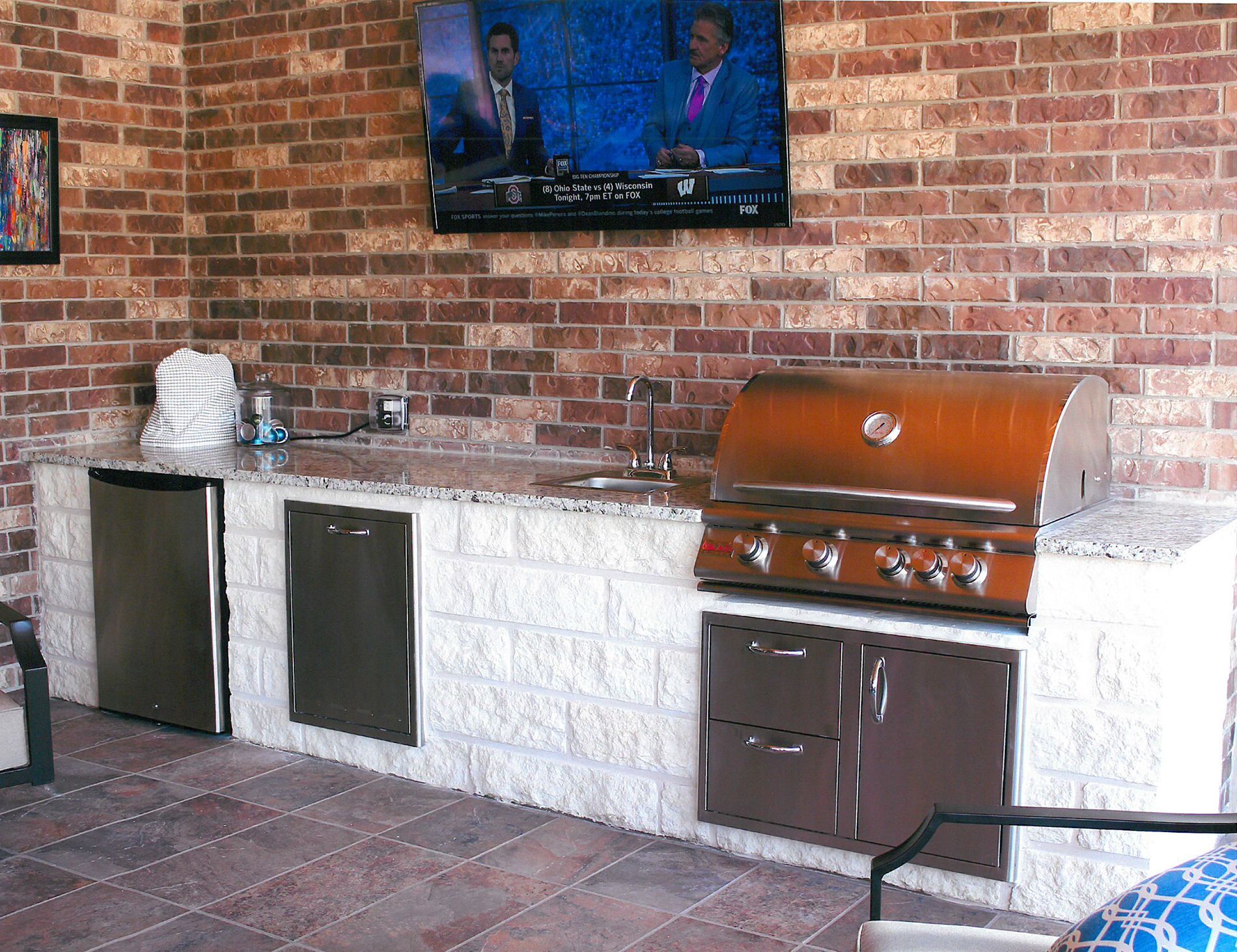 A kitchen with a grill and a television on the wall