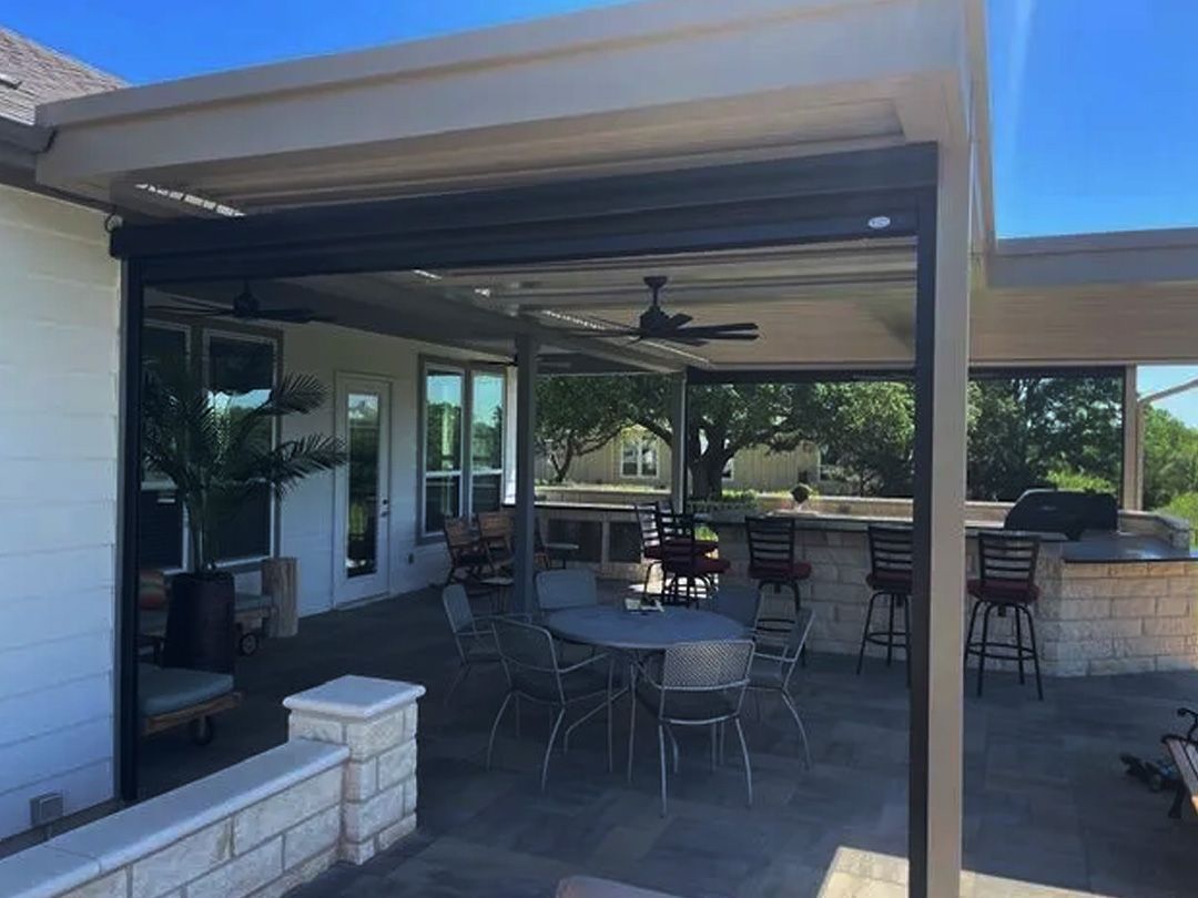 Patio with dining table, bar, and outdoor seating under a tan-colored pergola.