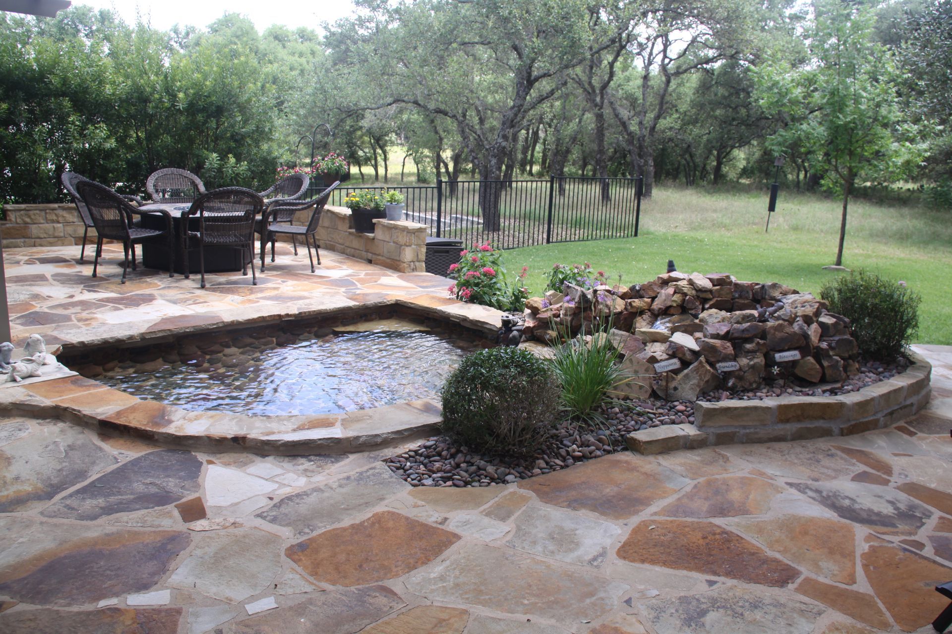 A patio with a table and chairs and a pond in the middle