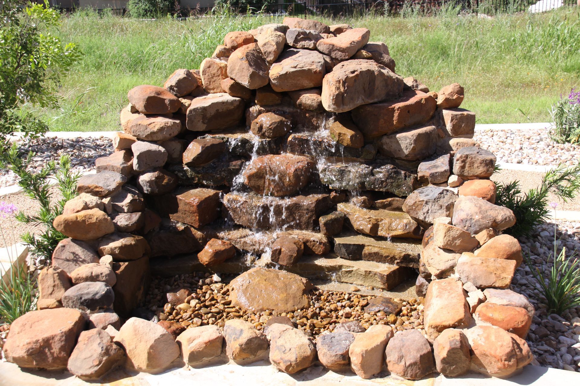 A waterfall made out of rocks in a garden