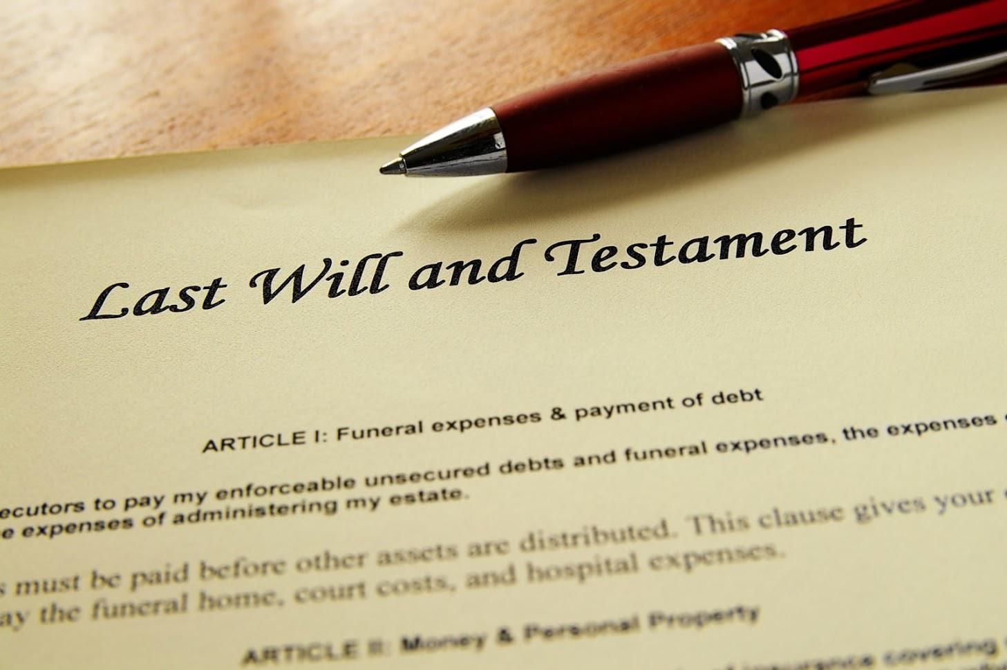 A Last Will and Testament document with a pen, detailing funeral expenses and property distribution.