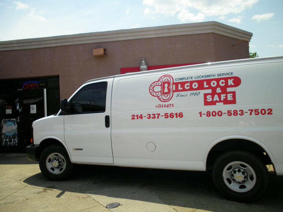 A white van is parked in front of a building