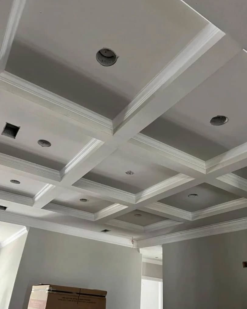 White coffered ceiling with crown molding and recessed lighting.