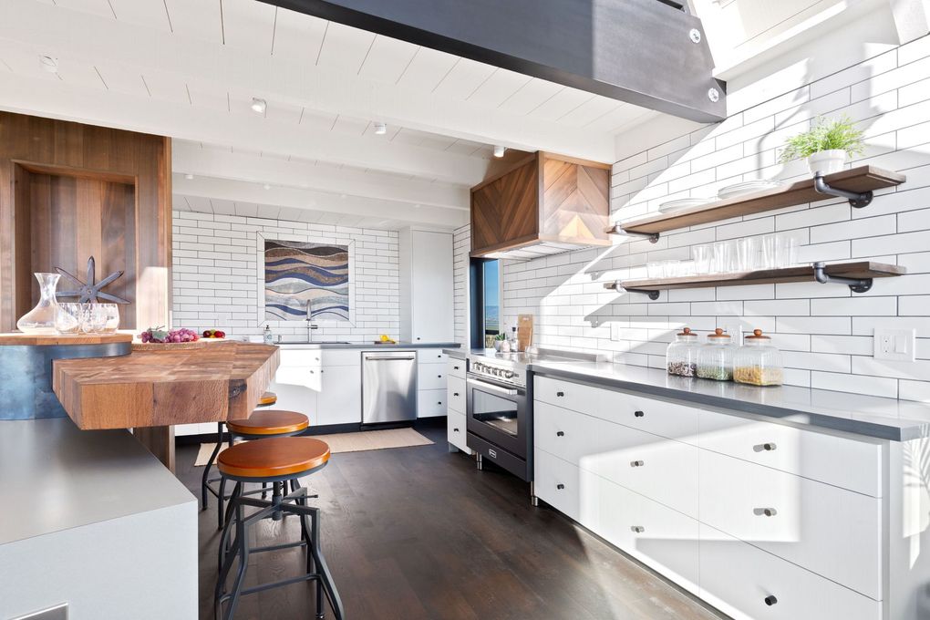 Modern kitchen with white brick walls, wooden accents, and stainless steel appliances.