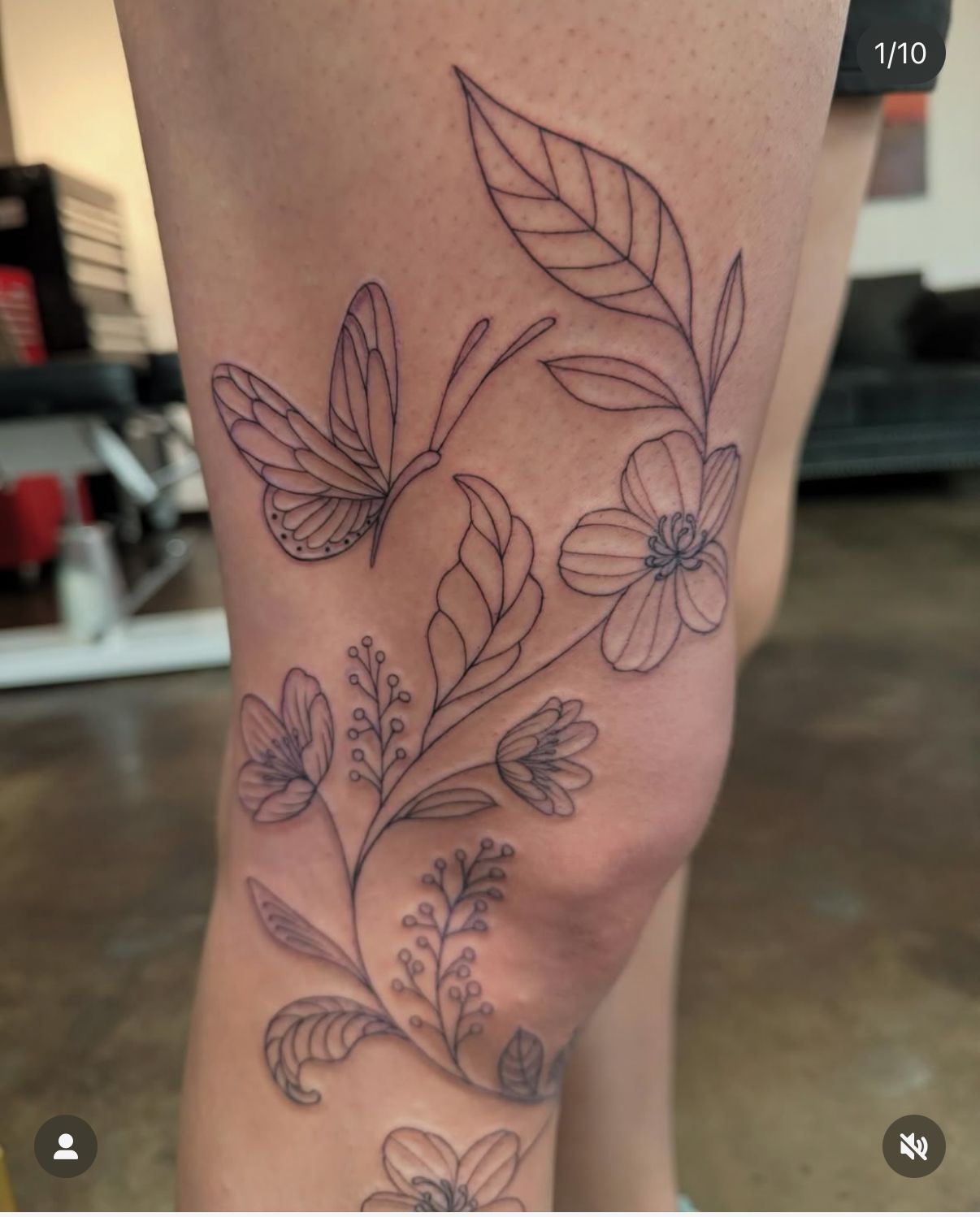 A woman has a tattoo of butterflies and flowers on her leg