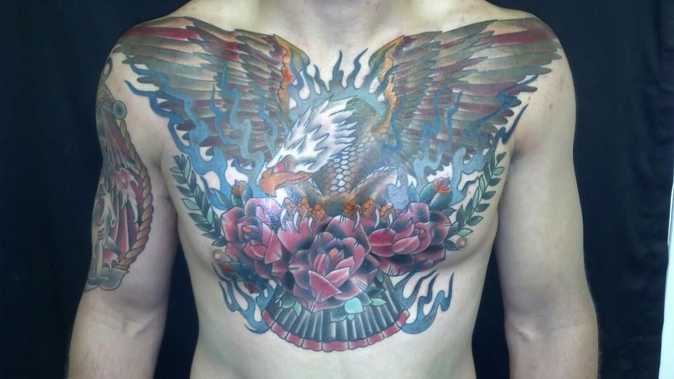 A man has a tattoo of an eagle on his chest.