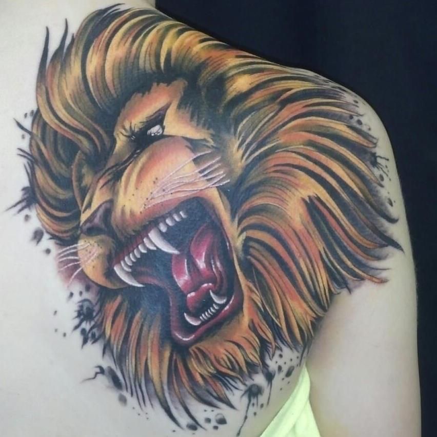 A woman has a tattoo of a lion on her shoulder