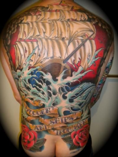 A man has a full back tattoo of a ship and roses