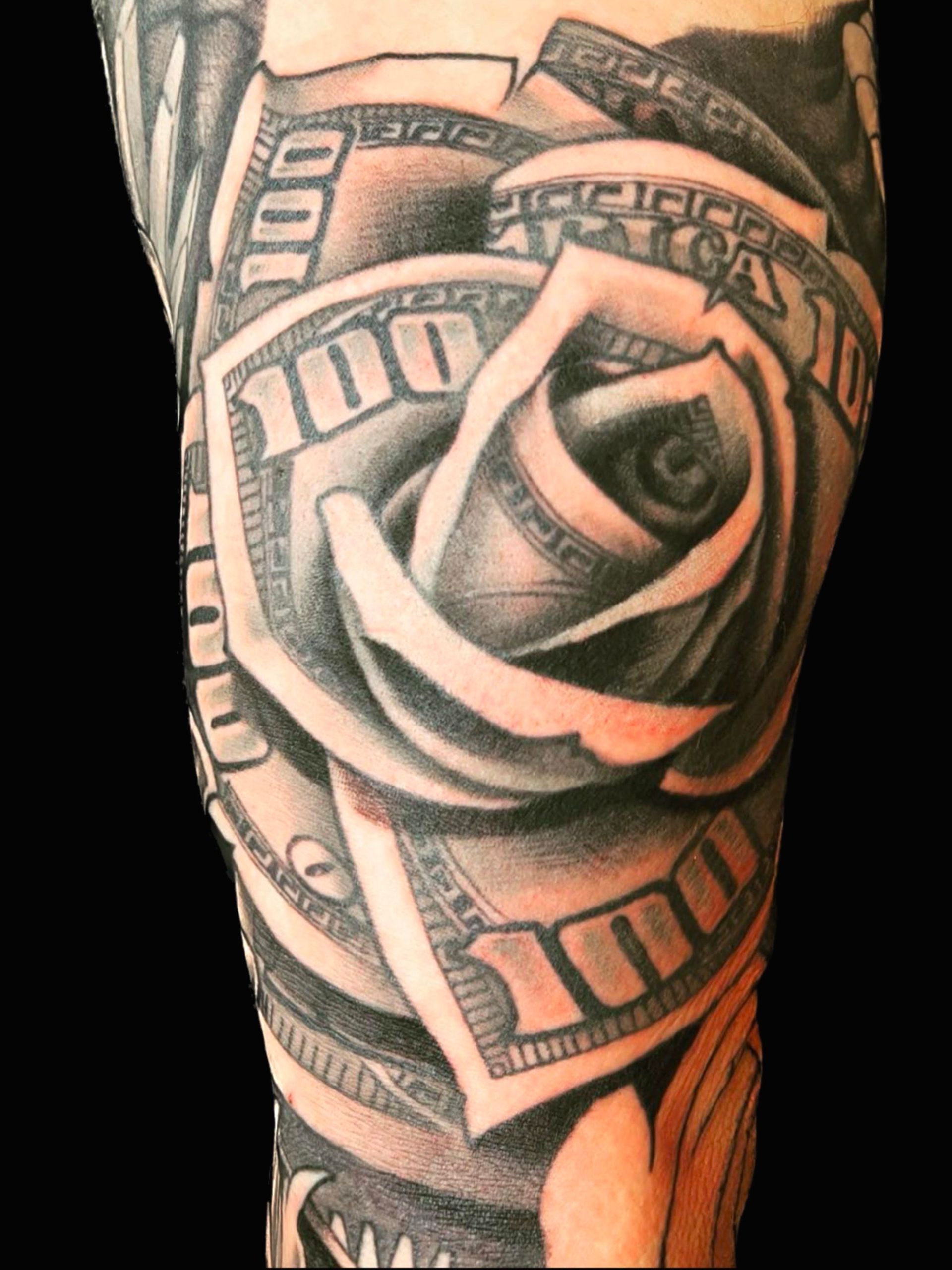 A tattoo of a rose made out of 100 dollar bills