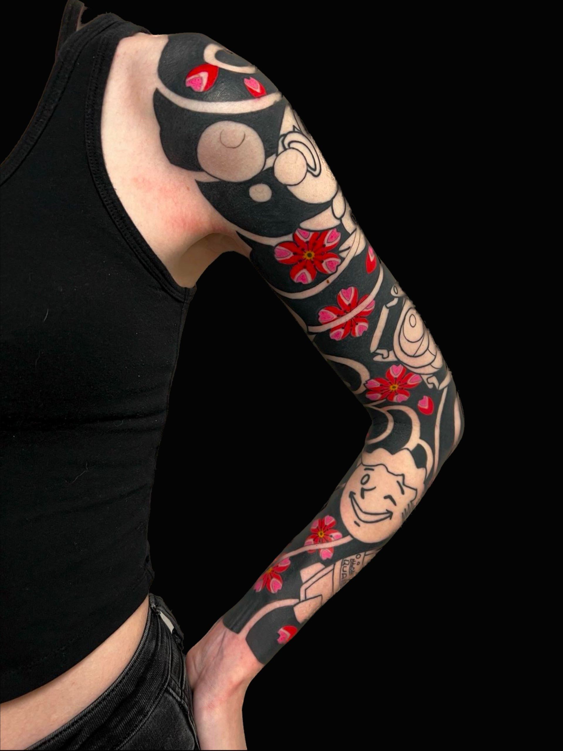A woman has a black and red tattoo on her arm.