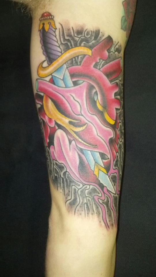 A tattoo of a heart with a dagger in it