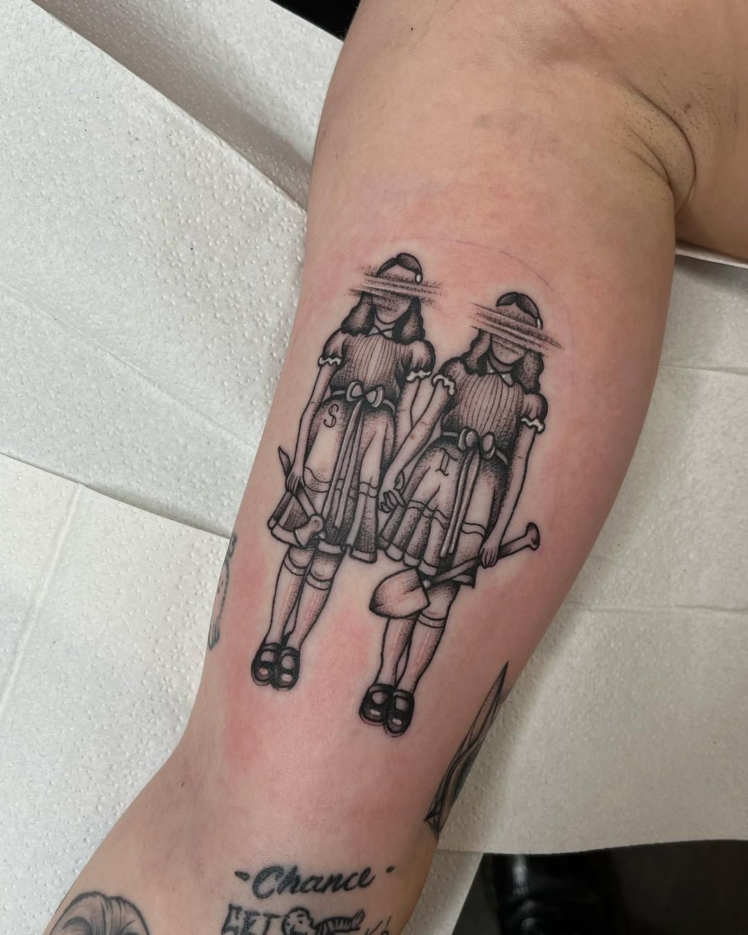 A tattoo of two women standing next to each other on a person 's arm