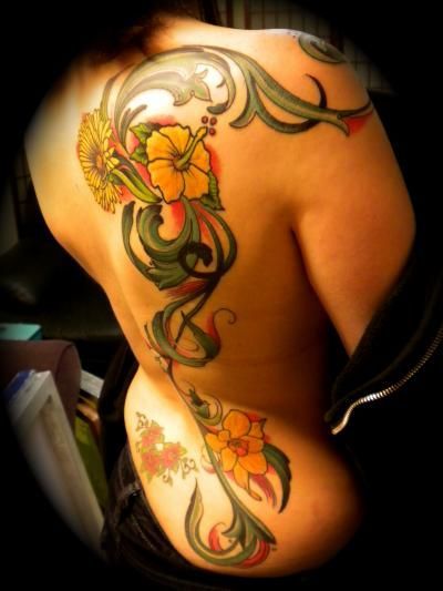 A woman has a tattoo of flowers on her back