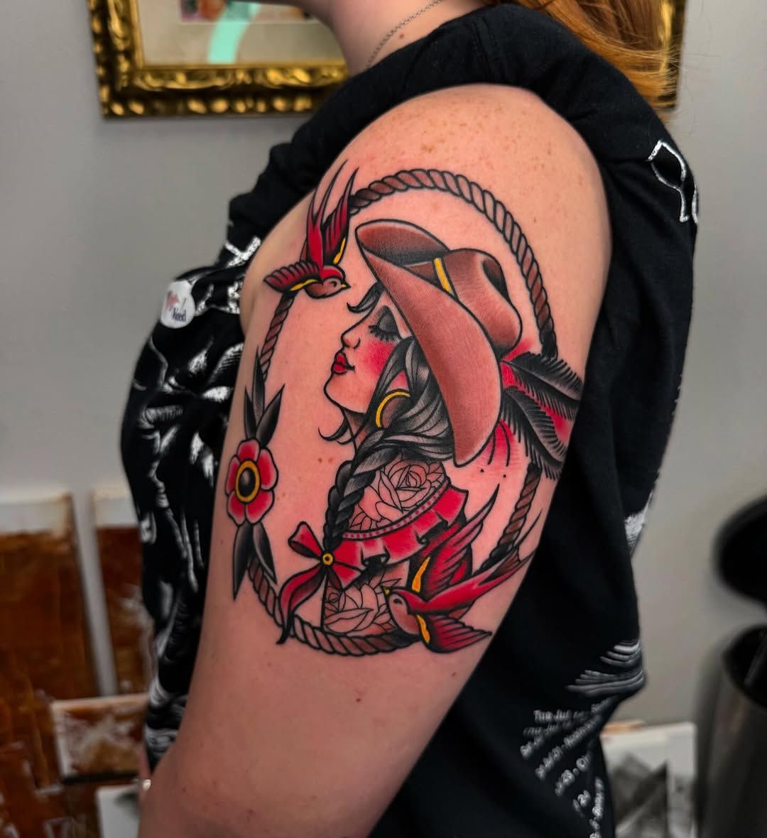 A woman has a tattoo of a woman wearing a cowboy hat