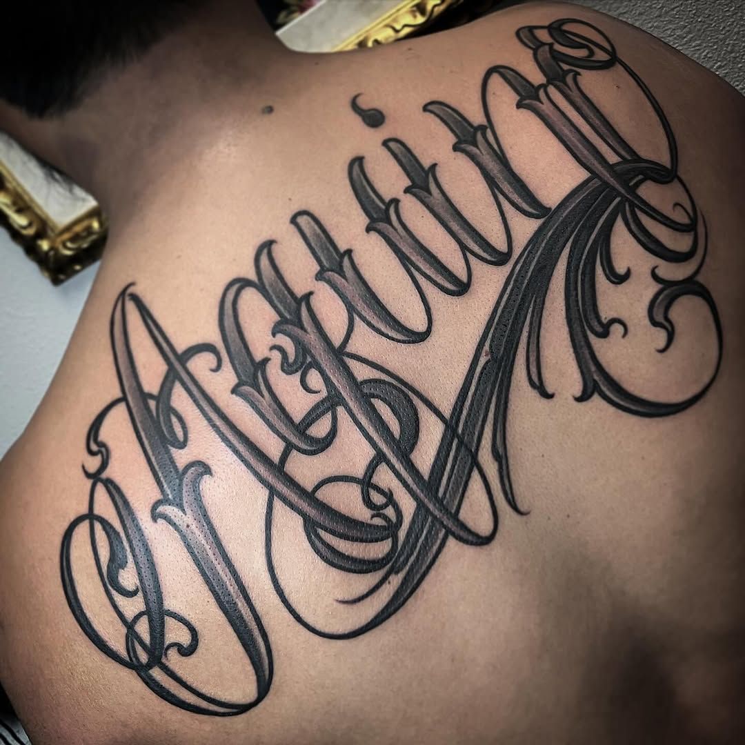 A man has a tattoo of the name martin on his back