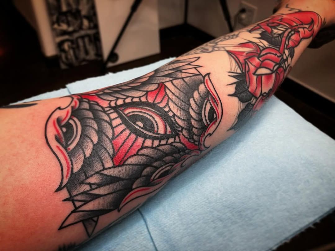 A person has a tattoo on their arm that looks like a dragon