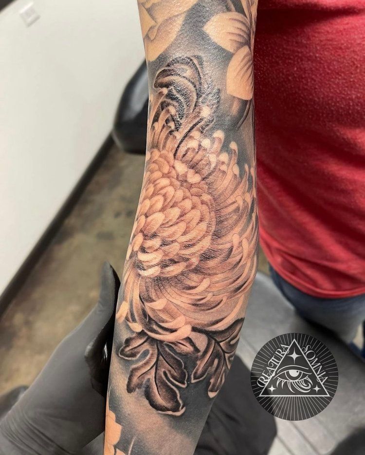 A person has a tattoo of a flower on their arm.