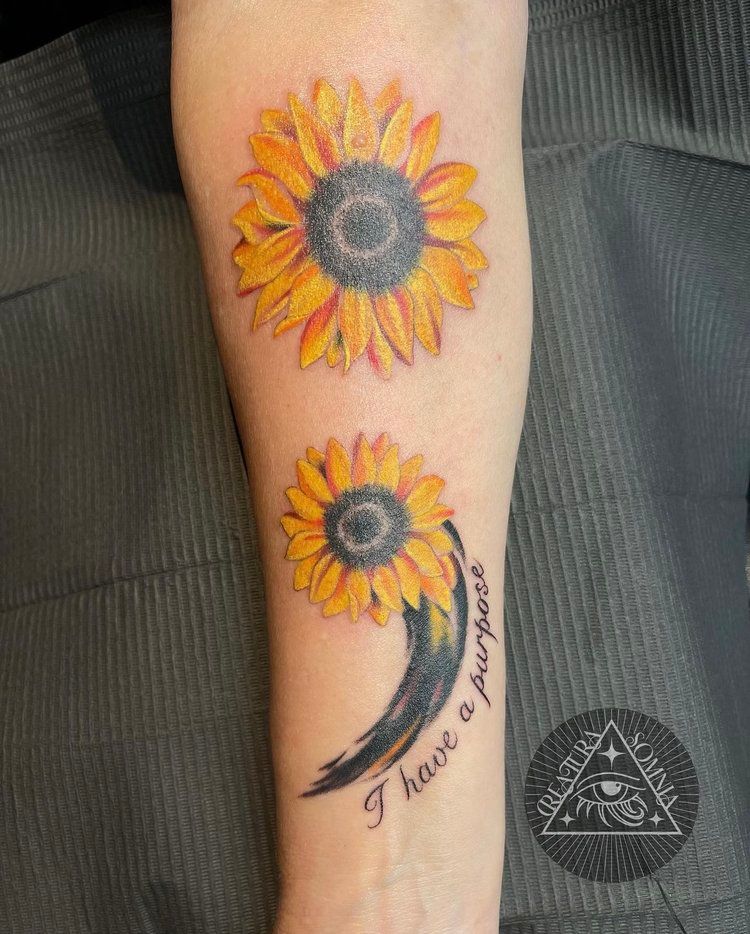 A woman has a tattoo of two sunflowers and the words `` i have a purpose '' on her forearm.
