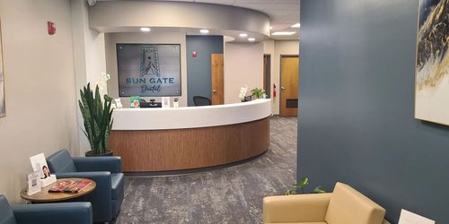 A waiting room with chairs and a counter in a dental office.