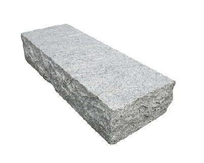 A gray stone block is sitting on a white surface.