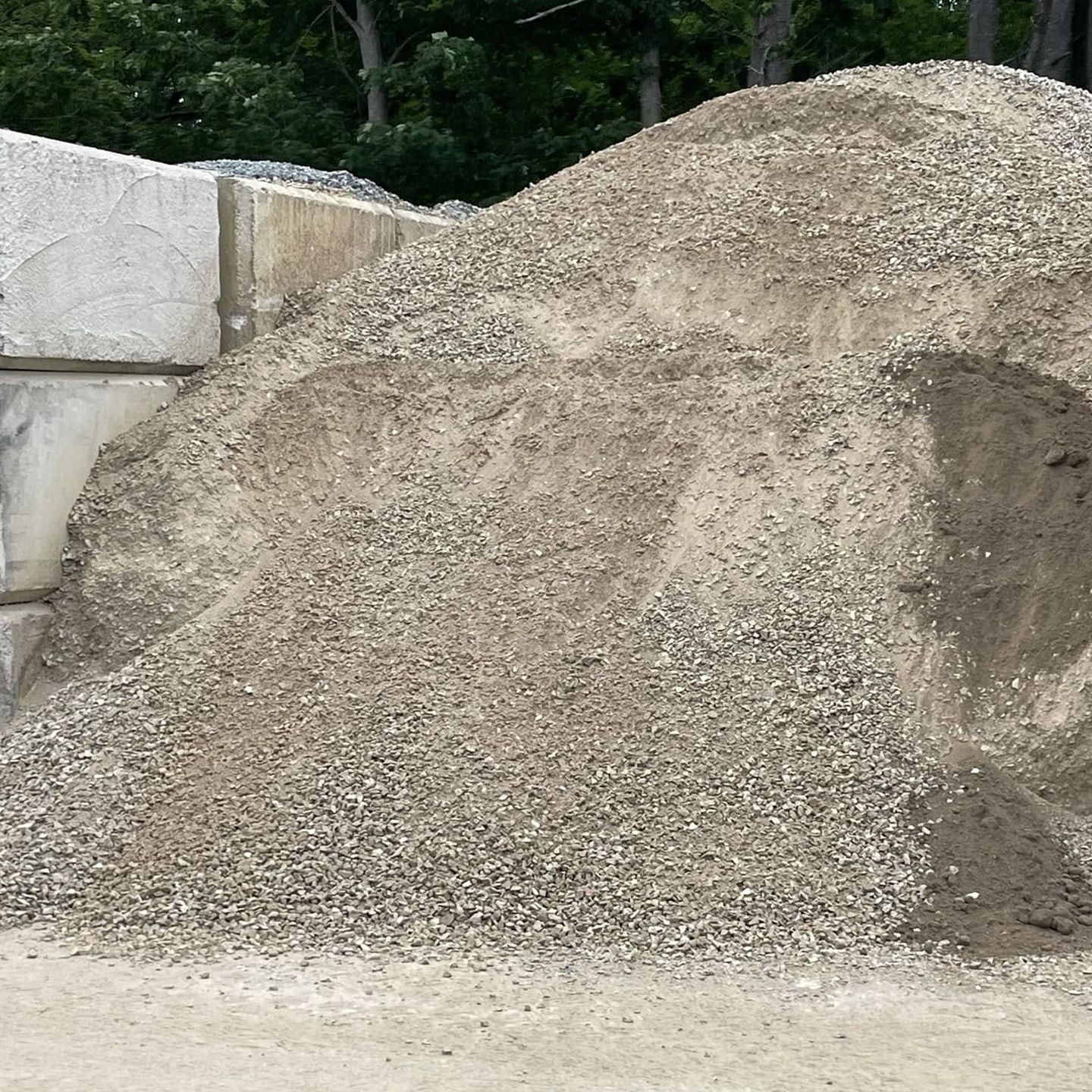 A pile of gravel is sitting on top of a dirt field.