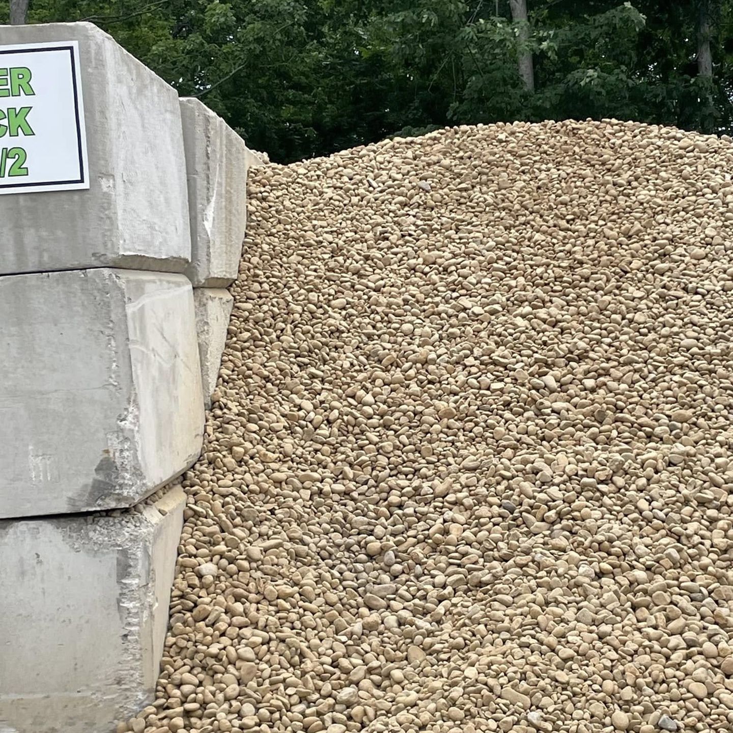A pile of gravel is sitting next to a pile of concrete blocks.