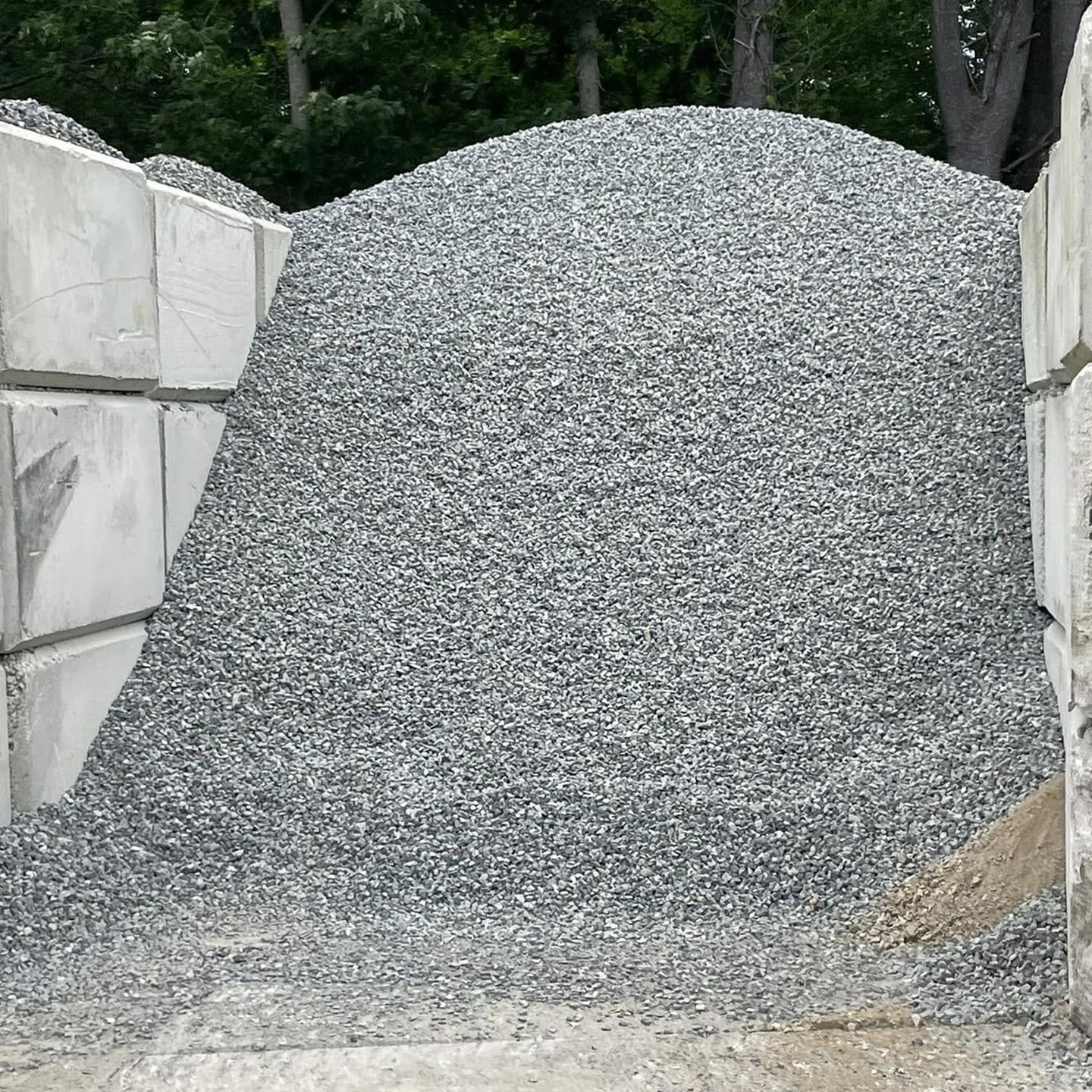 A pile of gravel is sitting on top of a pile of concrete blocks.