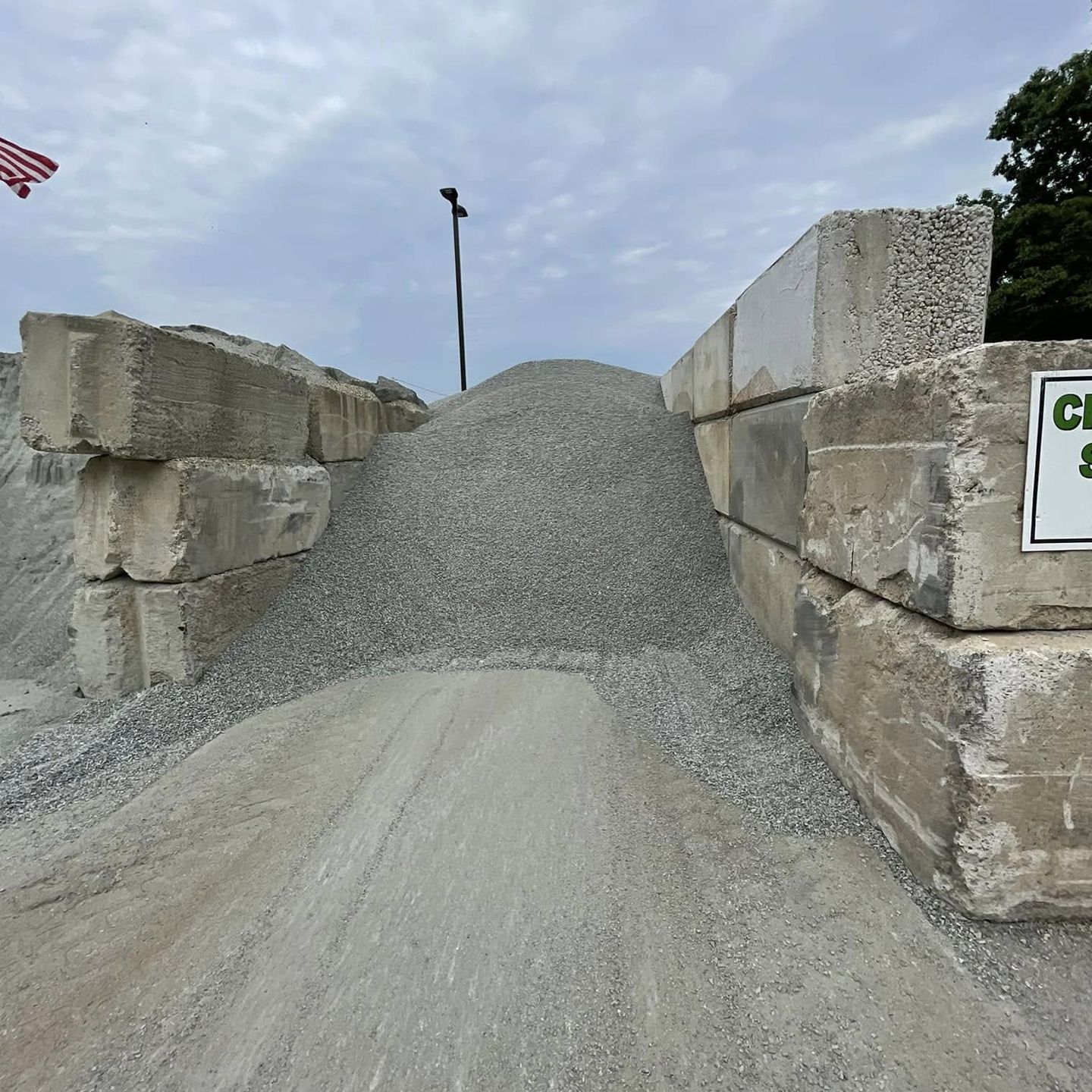 A pile of gravel next to a sign that says ' ci ' on it
