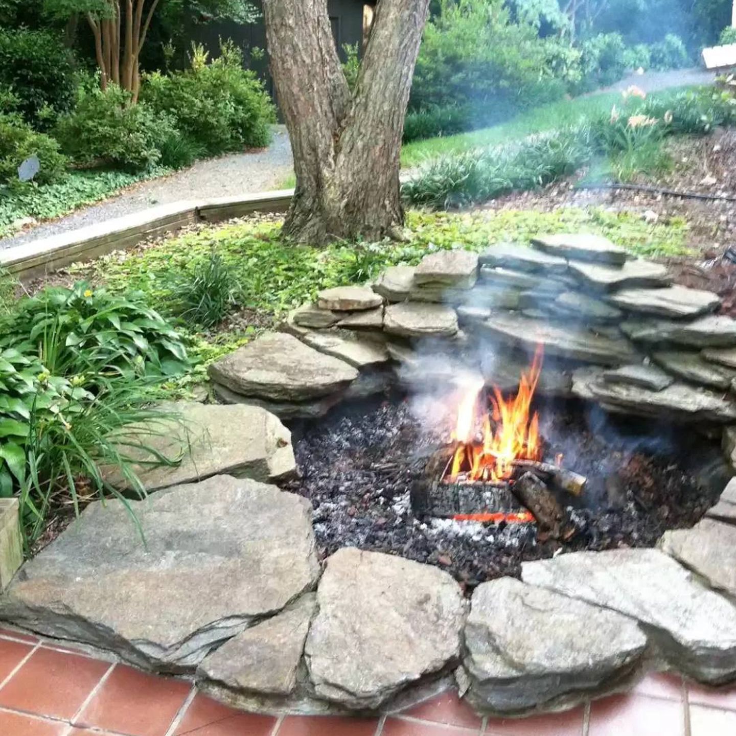 A fire pit surrounded by rocks in a garden