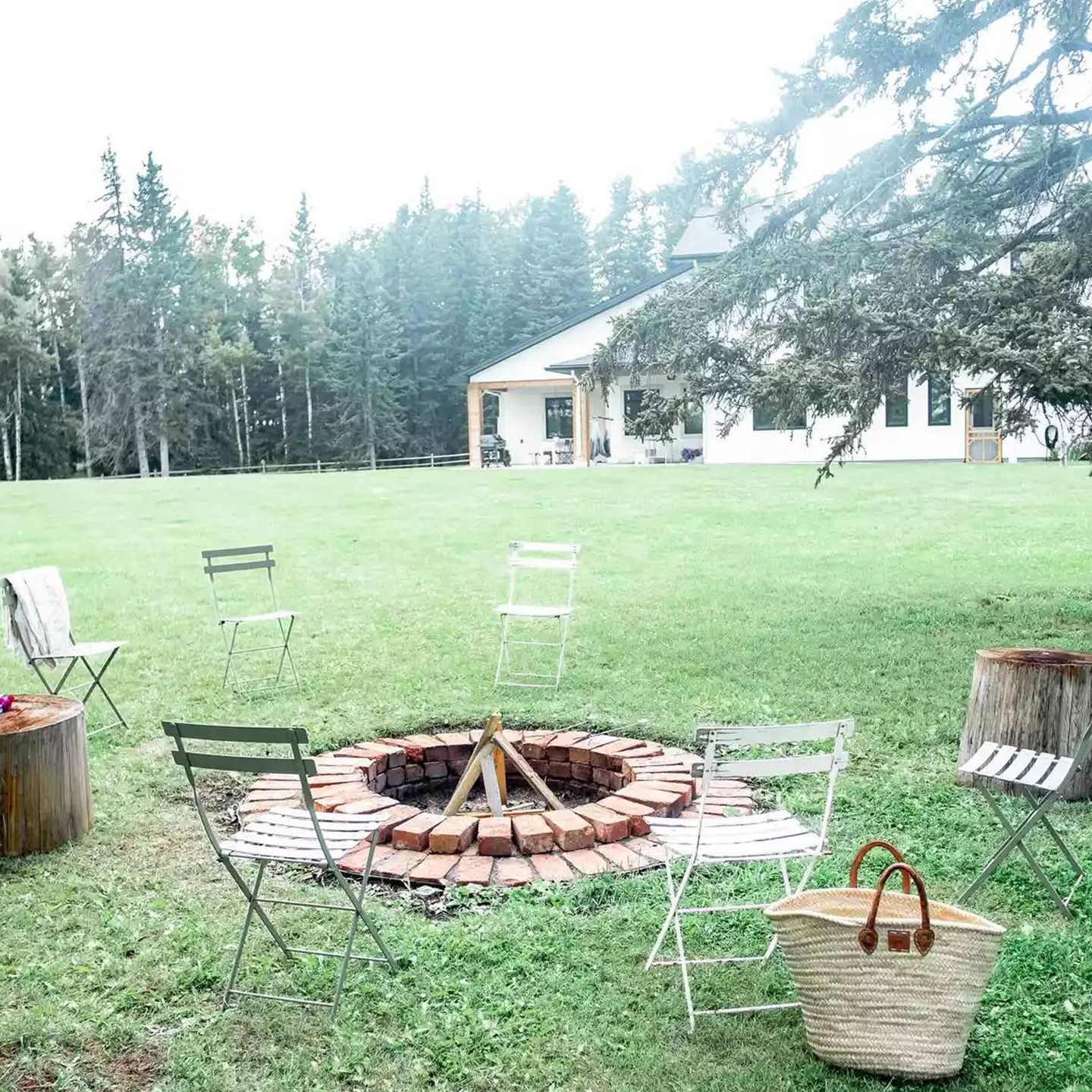 There is a fire pit in the middle of a grassy field.